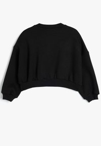 Sudadera recortada negra con cuello redondo, puños y cinturilla elásticos. Textura de tela suave y diseño holgado y relajado.