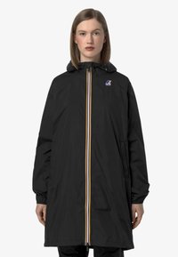 Veste imperméable noire avec capuche, dotée d'une fermeture éclair à l'avant avec des rayures jaunes et blanches, des poignets élastiques et des poches latérales.