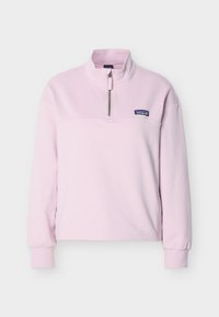 Ρόζ fleece πουλόβερ με φερμουάρ στο μπροστινό μέρος μέχρι το μεσόλαιμο, όρθιο γιακά, ριμπ μανσέτες και ετικέτα με το λογότυπο της Patagonia στο αριστερό στήθος.