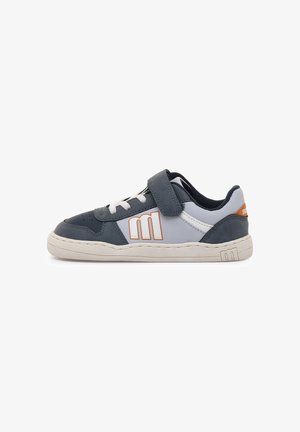 Zapatilla deportiva azul marino y gris con una correa de velcro, cordones blancos y suela de goma. Cuenta con un logo en naranja y detalles cosidos en los laterales.