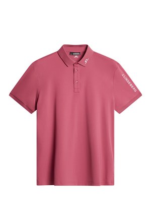 Lyserød polo-shirt lavet af glat materiale, med ribbet krave, tre-knap lukning og logo trykt i hvidt på ærmet.