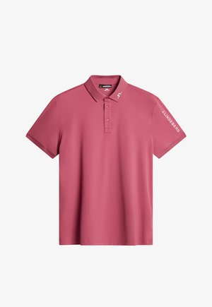 Vaaleanpunainen pörröpaida, joka on valmistettu sileästä kankaasta. Paidassa on ribbireunus kauluksessa, kolme nappia edessä ja valkoinen logo painettuna hihaan.