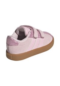 Roze antilop tenisice s glitrom, s dva Velcro remena, gumeni potplat i tri bijele pruge sa strane. Dizajn s zaobljenim potplatima.
