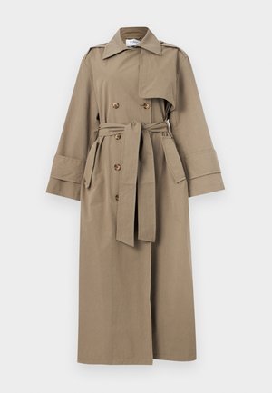 Μακρύ μπεζ παλτό τύπου trench με διπλή σειρά κουμπιών, ζώνη στη μέση, φαρδιά μανίκια και epaulets στους ώμους σε απλό φόντο.