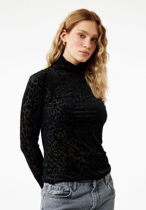 Haut turtleneck en imprimé léopard noir, fabriqué dans un matériau texturé et transparent, avec des manches longues et une silhouette ajustée.