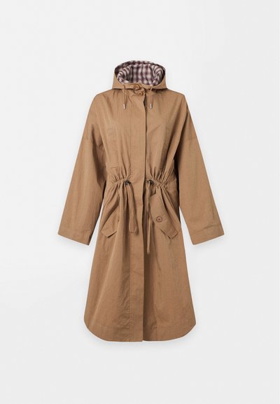 Long manteau marron à capuche avec une taille à cordon, deux poches avant à rabat avec boutons, et une doublure intérieure à carreaux dans la capuche.