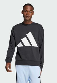 Sort sweatshirt med et stort hvidt adidas-logo foran, med lange ærmer og rund halsudskæring. Blød stofstruktur.