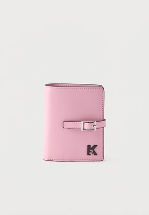 Pink leather wallet closed with a small silver buckle strap and a black "K" logo on the bottom right corner.