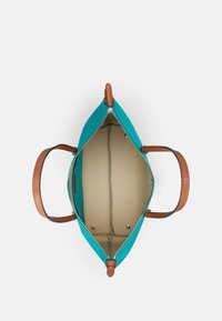 Mala de ombro com exterior em tela turquesa, alças em couro castanho, fecho com zíper e interior bege com compartimentos.
