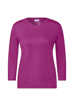 Maglietta a maniche lunghe con scollo a V di un vivace colore rosa, realizzata in morbido cotone; texture liscia con una vestibilità rilassata e dettagli di cucitura minimi.