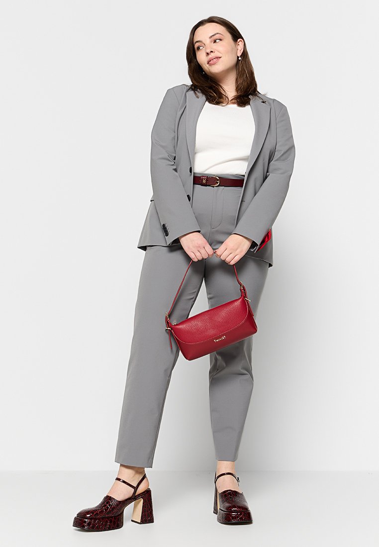 Completo grigio su misura con una blusa bianca, cintura bordeaux, borsa rossa e scarpe con tacco bordeaux con finitura testurizzata.