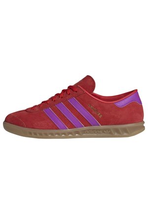 Niskoprofilowy czerwony zamszowy trampki Adidas z fioletowymi paskami, gumową podeszwą i napisem "Hamburg" złotymi literami po boku.