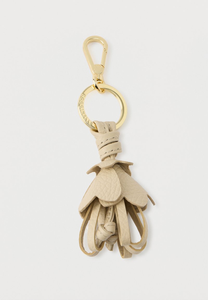 Portachiavi in pelle beige con design a frangia. Presenta un gancio in metallo dorato e un anello circolare. Texture liscia con dettagli sovrapposti.