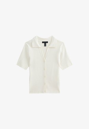 Kortärmad, kragad cardigan i vit ribbad tyg med knäppning framtill. Har en subtil textur och standard passform.