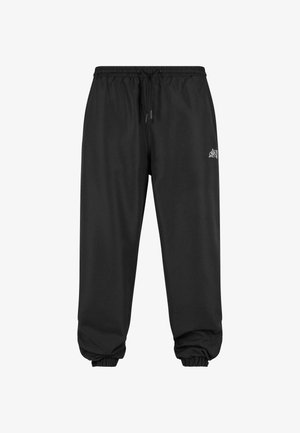 Black jogger pants with an elastic waistband and drawstring. Cuffs are fitted. Featured logo on the left thigh. Made from soft fabric.