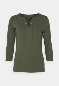 Zelený dlouhý rukáv top vyrobený z měkké látky, s V-výstřihem a šněrováním detailu s zlatými očky. Diskrétní logo na hrudi.