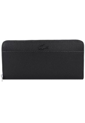 Portefeuille noir zippé avec un extérieur texturé et le logo Lacoste. Forme rectangulaire, tirette de zip lisse, avec un motif en forme de grille.