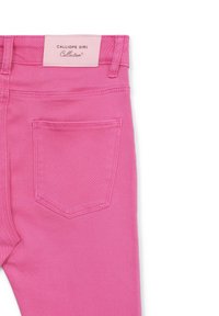 Rosa Jeans aus Denim mit Gesäßtasche und Gürtelschlaufen, versehen mit einem hellrosa Etikett, auf dem "CALLIOPE GIRL Collection" steht.