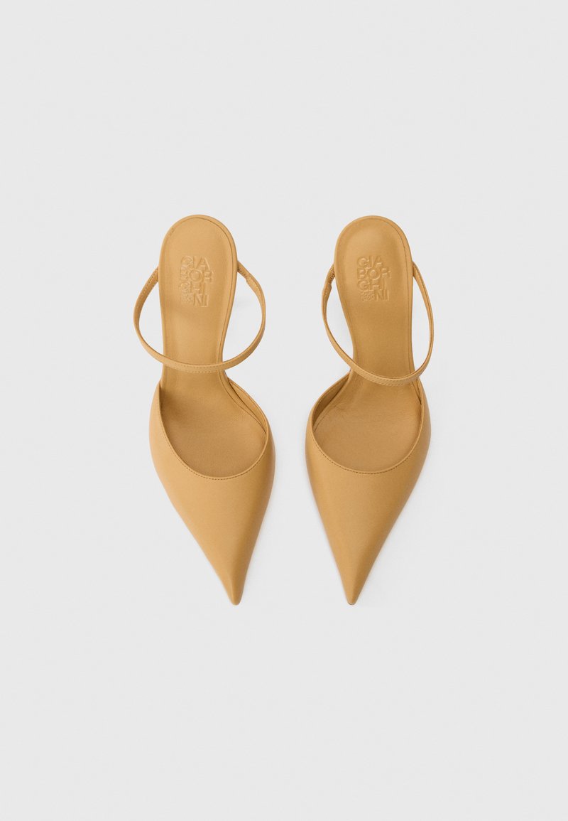 Une paire de talons slingback pointus beige avec des fines sangles et le nom de la marque en relief à l'intérieur, présentée de dessus sur fond blanc.