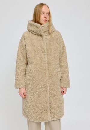 Beige Kunstpelzmantel mit hohem Kragen, vorderen Knöpfen und langen Ärmeln. Weiche Textur, knielanges Design mit seitlichen Taschen.