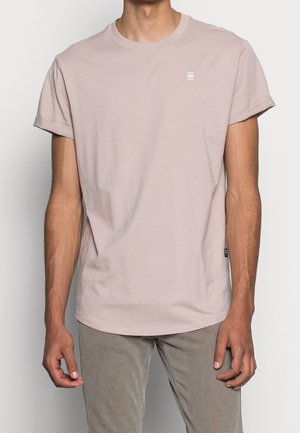 Jasnoróżowy bawełniany t-shirt z krótkim rękawem i okrągłym dekoltem. Mały szczegół z logo na piersi. Gładka faktura i regularny krój.