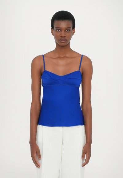Haut bleu vif à bretelles spaghetti avec un décolleté en cœur et une silhouette ajustée, mettant en valeur des détails texturés et une finition en tissu lisse.