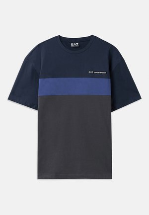 T-shirt in cotone blu navy con una striscia orizzontale blu e una sezione inferiore color carbone. Presenta un piccolo logo in alto a sinistra.