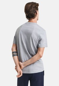 Grijze katoenen T-shirt met een ronde hals en korte mouwen; zachte textuur en relaxte pasvorm. Kenmerkt zich door een minimalistisch ontwerp zonder zichtbare branding.