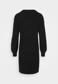 Longue robe-pull noire en maille avec de longues manches bouffantes et des poignets côtelés, vue de dos sur un fond uni.