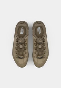 Beżowe buty trekkingowe z teksturowaną cholewką, okrągłym noskiem i sznurowanym zapięciem. Posiadają wyściełany kołnierz oraz wyraźne logo na wkładce.