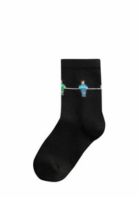 Calze nere con tre figure stilizzate in verde e blu, collegate da una linea bianca. Il materiale sembra essere morbido ed elastico.