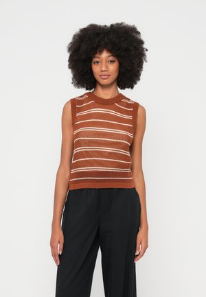 Hnedý bezrukávový pletený top s bielymi horizontálnymi pásmi a rebrovanou textúrou. V páre s čiernymi voľnými nohavicami.