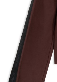 Pantalones deportivos marrones con un panel lateral negro que lleva la marca "FREDDY" en relieve. Tejido suave y texturizado, con un diseño de pierna cónica.