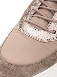 Nahaufnahme der Zehenpartie eines beigen Sneakers mit Wildleder, glattem Stoff und strukturierten Lederpaneelen sowie passenden Schnürsenkeln auf weißer Sohle.
