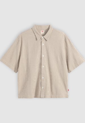 Μπεζ πουκάμισο κοντομάνικο με μικρό καρό μοτίβο και μυτερό γιακά, απλωμένο σε φωτεινό φόντο.