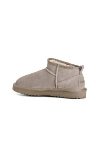 béžová semišová kotníčková bota s měkkým vnitřním podšíváním, prošívanými detaily, nízkým podpatkem a texturovanou gumovou podrážkou pro lepší trakci.