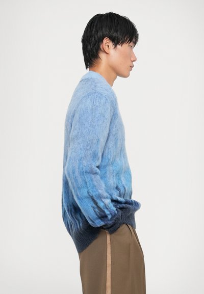 Maglione sfumato e morbido che transita dal blu chiaro al blu navy all'orlo. Realizzato in materiale soffice, con una vestibilità comoda e maniche lunghe.