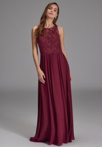 Burgunderfarbenes Abendkleid mit einer Spitzenoberteile, ärmellosem Design, fließendem Rock und aufwändigen Blumenmustern im oberen Bereich.