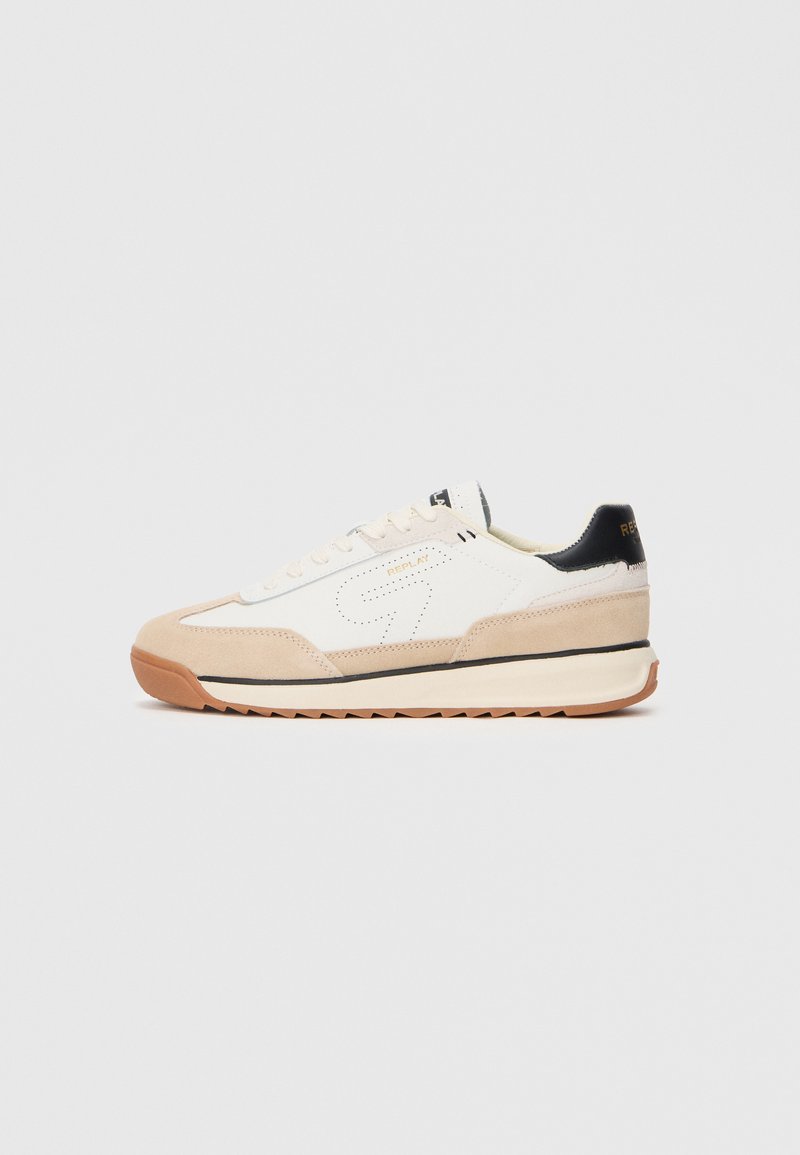 Sneaker bianco e beige con upper in suede e tessuto, accentuazione nera sul tallone, punta arrotondata e suola in gomma testurizzata con motivo zigzag.