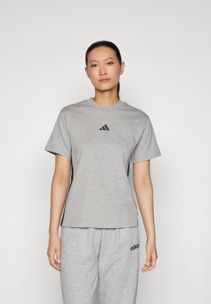 Pilkas trumpa rankovėmis marškinėliai, pagaminti iš minkštos medžiagos, su maža juoda Adidas logotipo užrašą ant krūtinės, derinami su atitinkančiais pilkais treniruokliais.