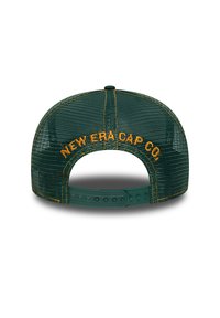 Gorra de malla verde con costuras amarillas, con "NEW ERA CAP CO." bordado en la parte trasera. Cierre de correa ajustable de plástico.