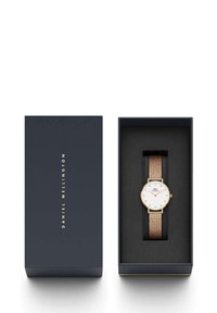 Arany hálós szíjas óra tengerészkék dobozban. Fehér számlappal, arany órjelek és minimalista dizájn. Puha fekete belső bélés.
