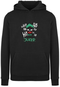 Svart hettegenser med et grafisk trykk av et hodeskalle med grønt hår og røde aksenter, tekst "JOKER," og gjentatte "ha" uttrykk i hvitt. Forlomma.