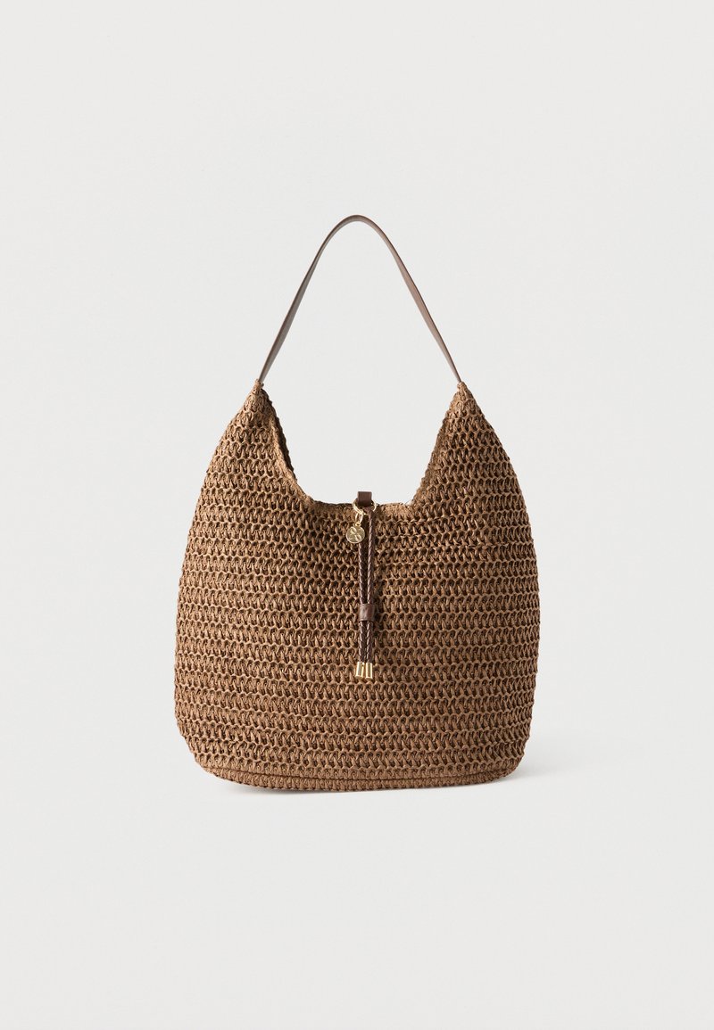 Sac d'épaule tressé marron avec une seule bandoulière et un détail à pompon sur le devant orné d'accents dorés, présenté sur un fond blanc uni.