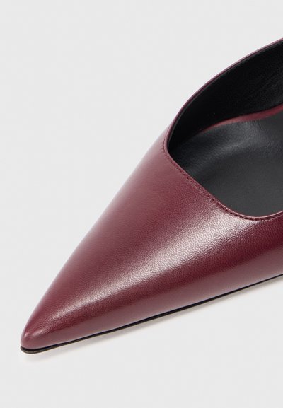 Cipele za haljinu od burgundske kože s oštrim vrhom, glatke završne obrade i crnim unutarnjim oblogama na bijeloj pozadini.