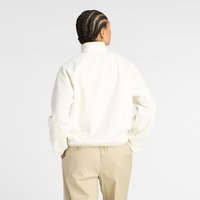 White fleece jacket with a high collar, featuring a soft texture and raglan sleeves, paired with light beige trousers.