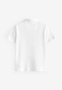 Polo-shirt blanc à manches courtes avec un col classique, fabriqué à partir d'un tissu lisse, présentant un design épuré et simple sans motifs ni accents visibles.
