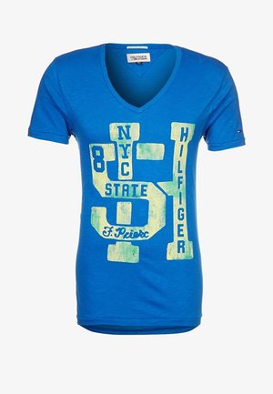 Modré bavlněné tričko s výstřihem do V, zdobené velkým grafickým potiskem v bílé a zelené barvě, obsahujícím čísla a text, s krátkými rukávy.