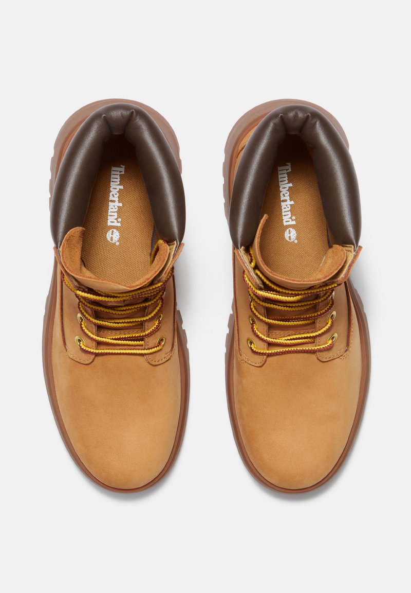 Stivali in pelle marrone con punte arrotondate, colli imbottiti, lacci gialli e suole in gomma. Logo Timberland visibile sulle solette.