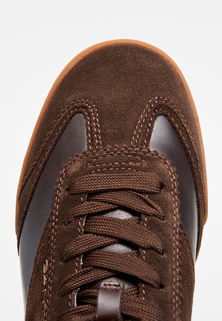 Schwarze Wildleder-Sneaker mit Lederakzenten, Gummisohle und runden Schnürsenkeln. Verfügt über eine Steppnaht und eine glatte Zehenpartie.